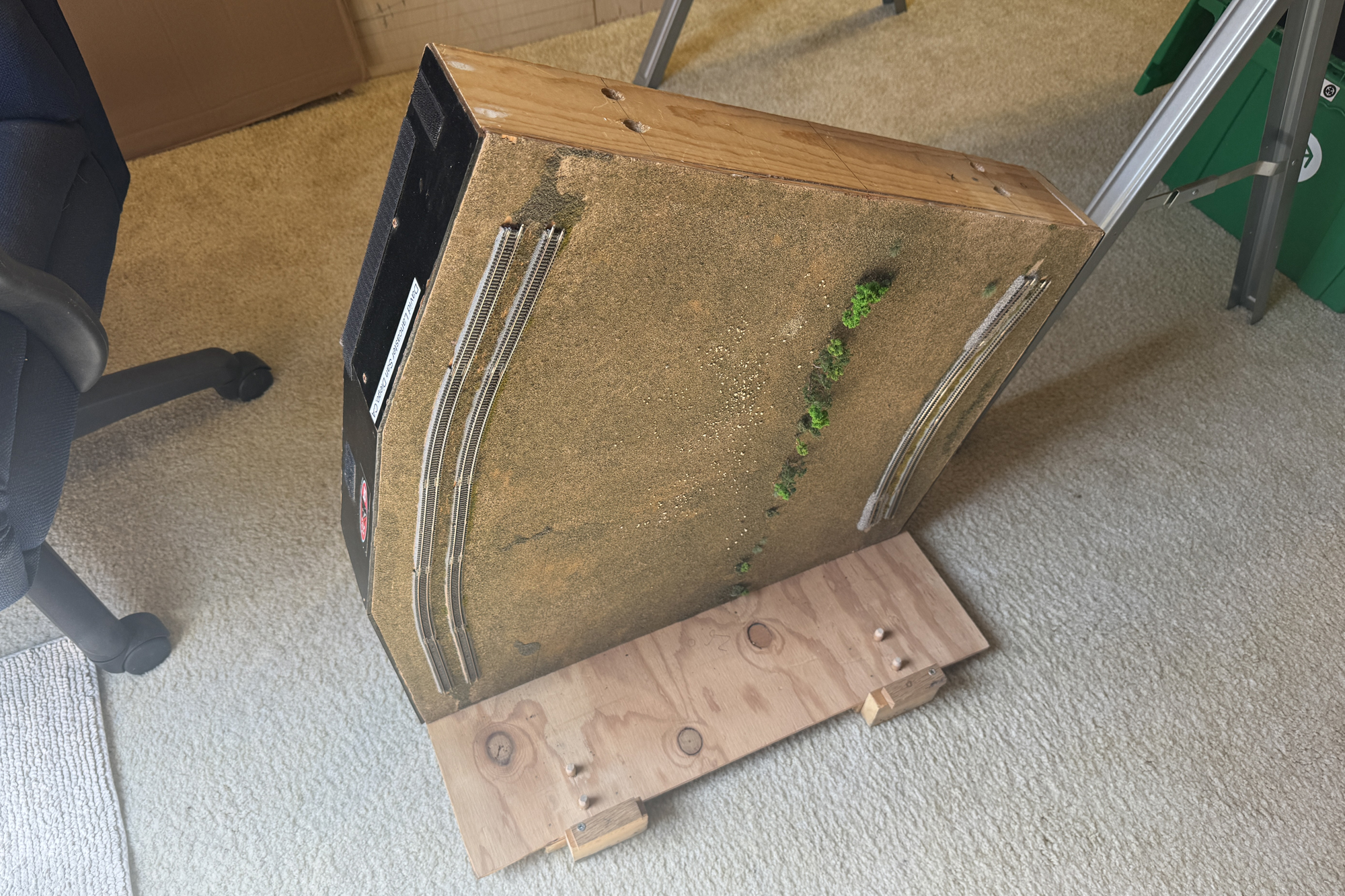 Z scale module on the floor with part of the tranportation clamp showing. Another module will be placed on the clamp. Z scale module on the floor with part of the tranportation clamp showing. Another module will be placed on the clamp.